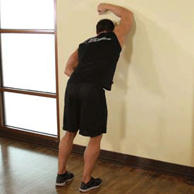 Растяжка широчайших мышц спины стоя с опорой на стену